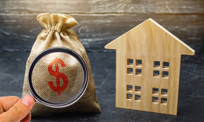 A bag with money and wooden house. Selling a house. Apartment purchase. Real estate market. Rental...