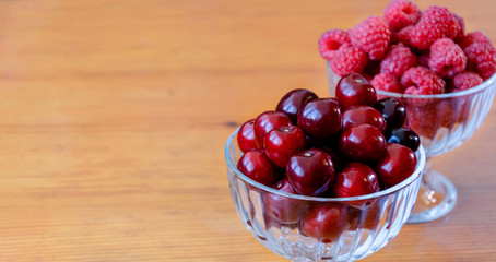 red berry of raspberry and cherry in bulk in glass bowls
