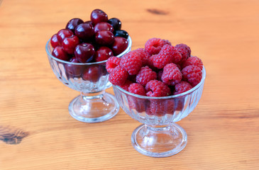red berry of raspberry and cherry in bulk in glass bowls
