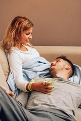 Young smiling couple together on sofa looking at each other