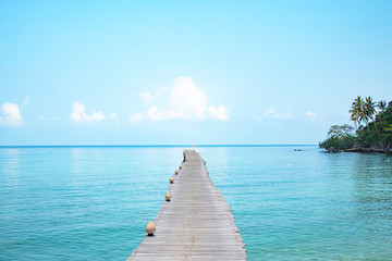 Wooden bridge pier boat in the sea and the bright sky.