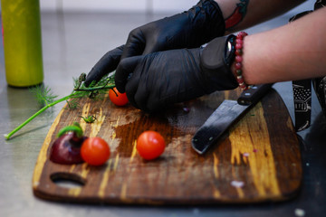 Girl chef slicing vegetables. Tomatoes, parsley, onion, apple. Wooden board for slicing vegetables.Curtain processes