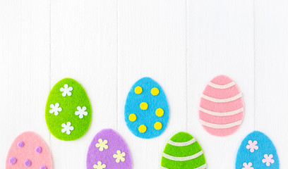 Closeup top view photo of cute diy colorful pastel eggs decorated with dots, stripes and flowers isolated on white painted wooden background. Happy Easter holiday greeting cards. Horizontal image.