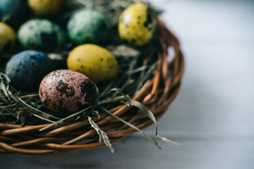 Quail Easter eggs in a basket on the hay. Easter concept