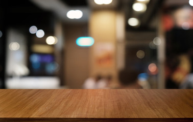 Empty dark wooden table in front of abstract blurred bokeh background of restaurant . can be used for display or montage your products.Mock up for space.