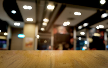 Fototapeta premium Empty dark wooden table in front of abstract blurred bokeh background of restaurant . can be used for display or montage your products.Mock up for space.
