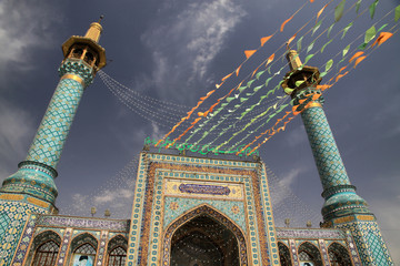 kolorowe flagi zdobiące fasadę zabytkowego meczetu w iranie podczas święta