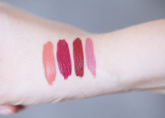Female arm with lipstick tone color and testing different lipsticks