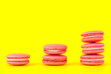 Pink macaroons on a yellow background. Concepts of classification and growth