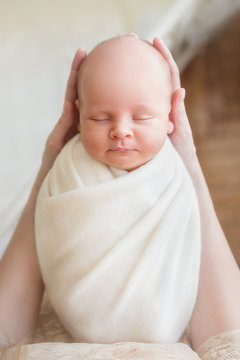 Newborn baby boy sleeping in mom's arms