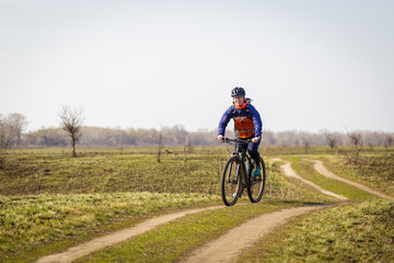 Fototapeta na wymiar woman cyclist riding a bicycle in the field