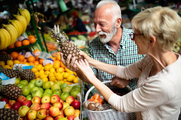 Senior shopping couple with basket on the market. Healthy diet.