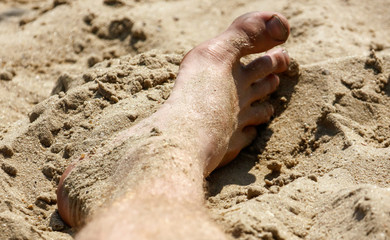 Feet of a man in the sand