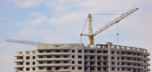 Fototapeta na wymiar Crane is building a multi-storey house