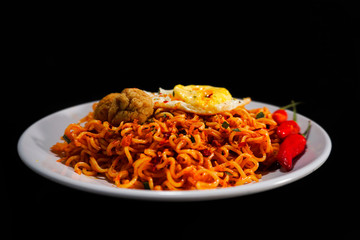 Spicy Noodle with meatball and egg isolated on black background