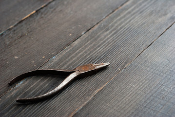 old pliers on black wooden