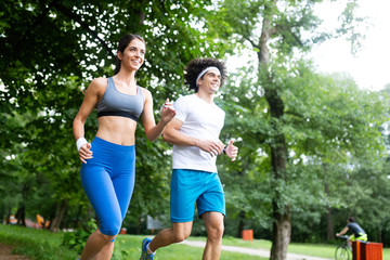 Happy young woman doing excercise outdoor in a park, jogging
