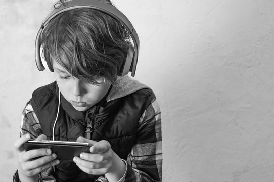 Young boy and girl play games and listen to music on their mobile phones  7468482 Stock Photo at Vecteezy