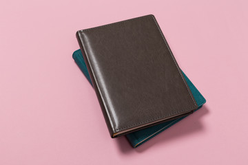 top view of a open notebook on a pink background.