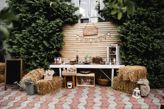 Wedding banquet decorations. Wood rustic style decor. Festive table with desserts, snacks, cakes, blackberry and popcorn. Receptions Tarlets. Decorations made of wood with flowers and greenery.  