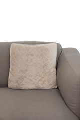 Corner fragment of beige grey upholstered couch with velour decorative cushion on white wall...