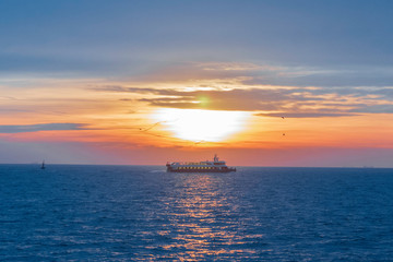 Naklejka na ściany i meble The ship sailing at a beautiful sunset over the sea in Istanbul