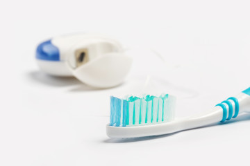 Dental floss and toothbrush isolated on a white background.