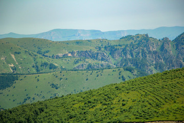 The Caucasus Mountains, high mountains, green meadows and snow-capped mountains.