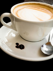 Cup of coffee latte and coffee beans isolated on black background