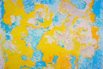 Close-up of old blue and yellow damage wall.