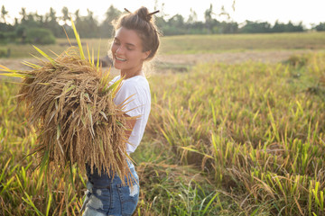 Happy woman farmer during harvesting on the rice field