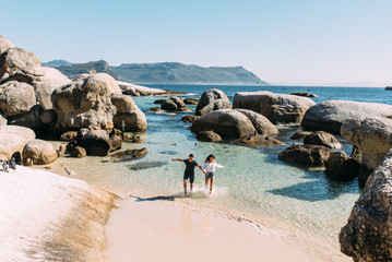 Junges Paar voller Liebe, Freude und Freiheit am Strand Boulders Beach im sonnigen Kapstadt in...