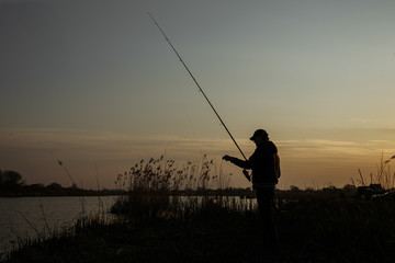 Silhouette of a fisherman against the sky