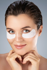 Woman with hydrating eye patches under her eyes o