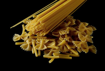 Spaghetti, farfalle noodles and macaroni, yellow pasta isolated on black background, clipping path