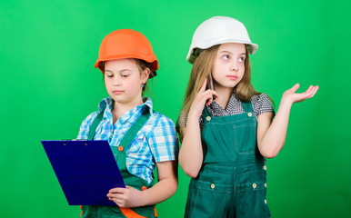 Little kids in helmet with tablet. small girls repairing together in workshop. school project. Labor day. 1 may. Foreman inspector. Repair. Tired mechanic. Now I see the problem