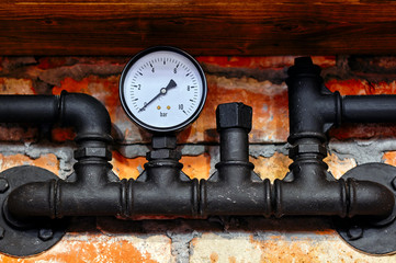 Old black pipeline and pressure gauge