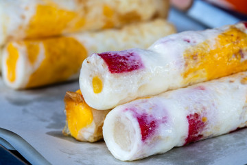 Rolled omelet together with seafood for sale at the street food market in island Koh Phangan, Thailand . Closeup