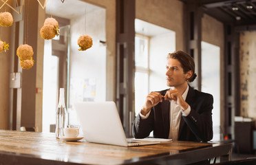 Young handsome businessman conducting negotiations with investors. Electronic business. Alternative...