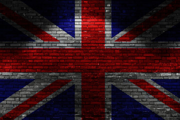 GB flag on brick wall at night