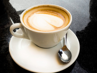 Cup of coffee latte and coffee beans isolated on black background