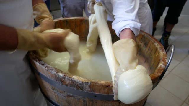 two people melt the cheese to make Italian mozzarella and caciocavallo cheese. Sannio, Benevento, Campania, Italy