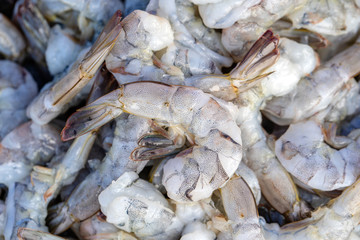 Peeled sea shrimps at street market in Thailand. Seafood concept. Raw prawns for cooking, close up