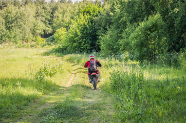Fototapeta premium A man on a motocross bike rides along the forest