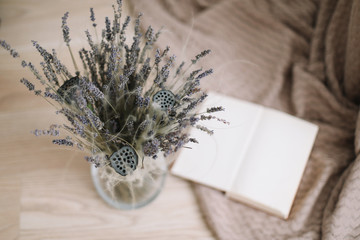 Still life with a bouquet of dried flowers and a book on wooden background. Provence and rustic style, top view, flatlay 