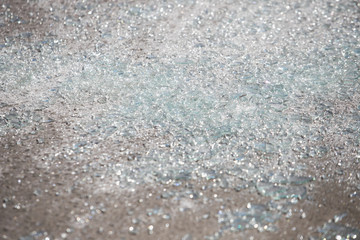 Shards of broken car glass on the asphalt road