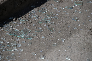 Shards of broken car glass on the asphalt road