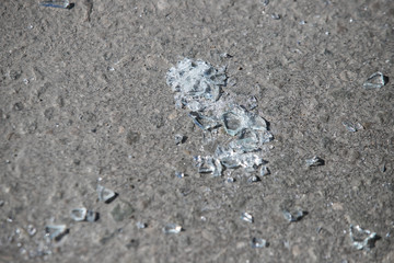 Shards of broken car glass on the asphalt road