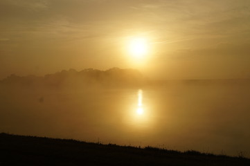 Obraz premium spiegelung, sonnenspiegelung, sonnenaufgang am Fluss, nebel