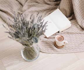  Dried flowers and a cup of cappuccino  with book on wooden background. top view. flatlay